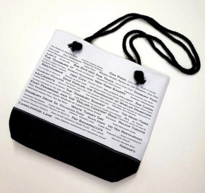 A white bag with black cord and words on it.