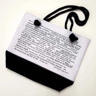 A bag with a black strap and white paper.