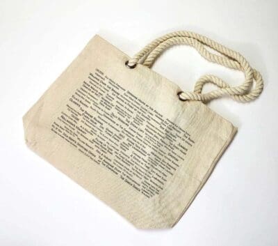 A bag with a rope handle and an old book page.