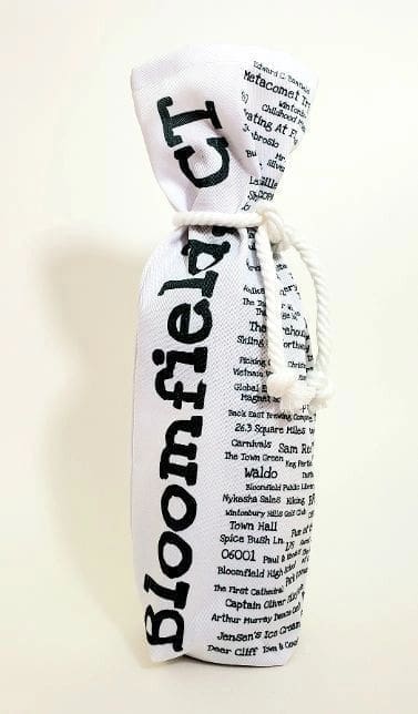 A bottle of wine wrapped in newspaper.