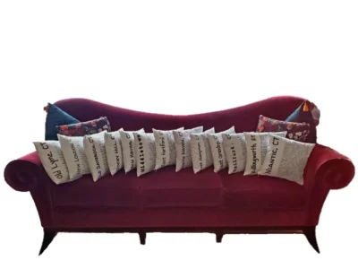 A red couch with many pillows on it