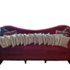 A red couch with many pillows on it