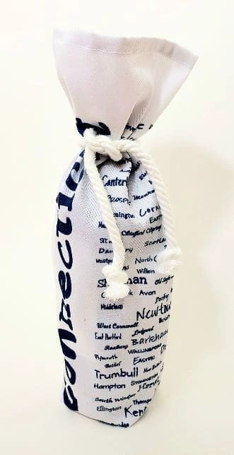 A bottle of wine is wrapped in a white ribbon.