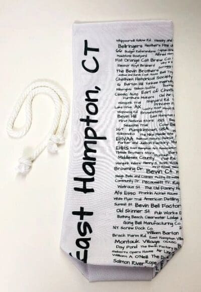 A white neck tie with black writing on it.