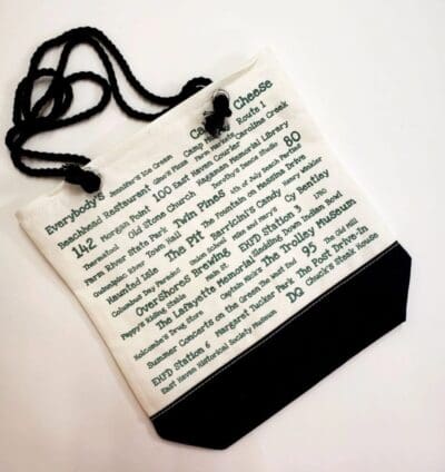 A white bag with black string and a poem written on it.