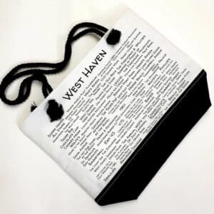 A white bag with black handles and a newspaper page.