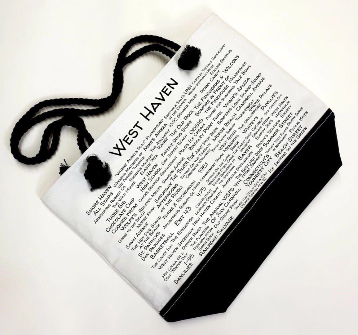 A white bag with black handles and a newspaper page.