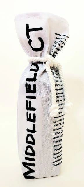 A bottle of wine is wrapped in newspaper.