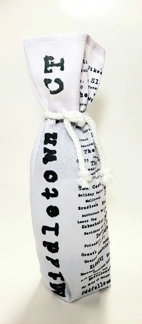 A bottle of wine wrapped in newspaper.