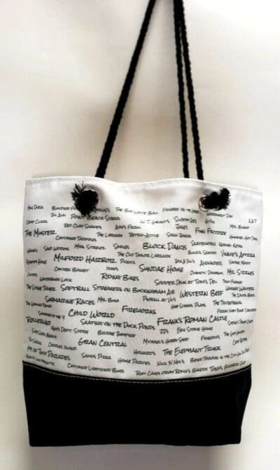 A white bag with black handles and writing on it.