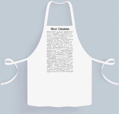 White New Canaan Pride Chef's apron printed on the front, displayed against a plain gray background.