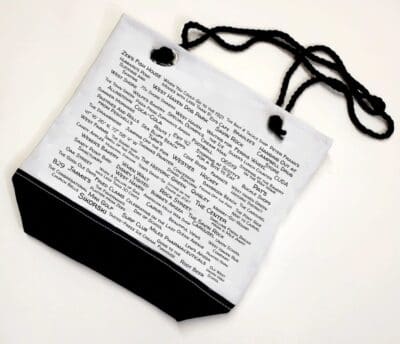 A white bag with black handles and a text on it.