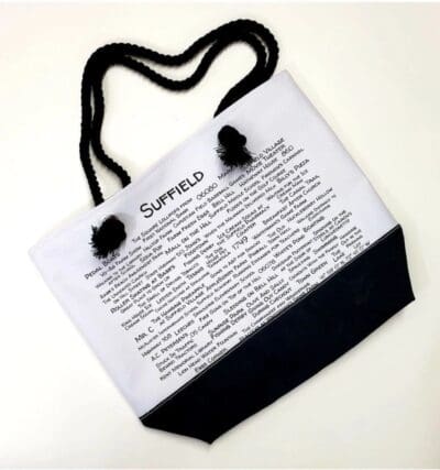 A white bag with black handles and a text on it.