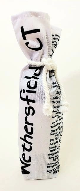 A bottle of wine is wrapped in a white bag.