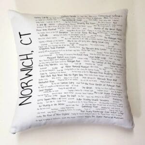 A pillow with writing on it is sitting on the wall.