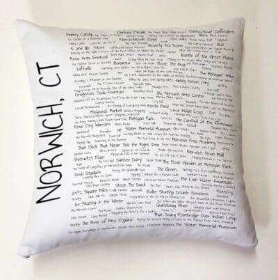 A pillow with writing on it is sitting on the wall.