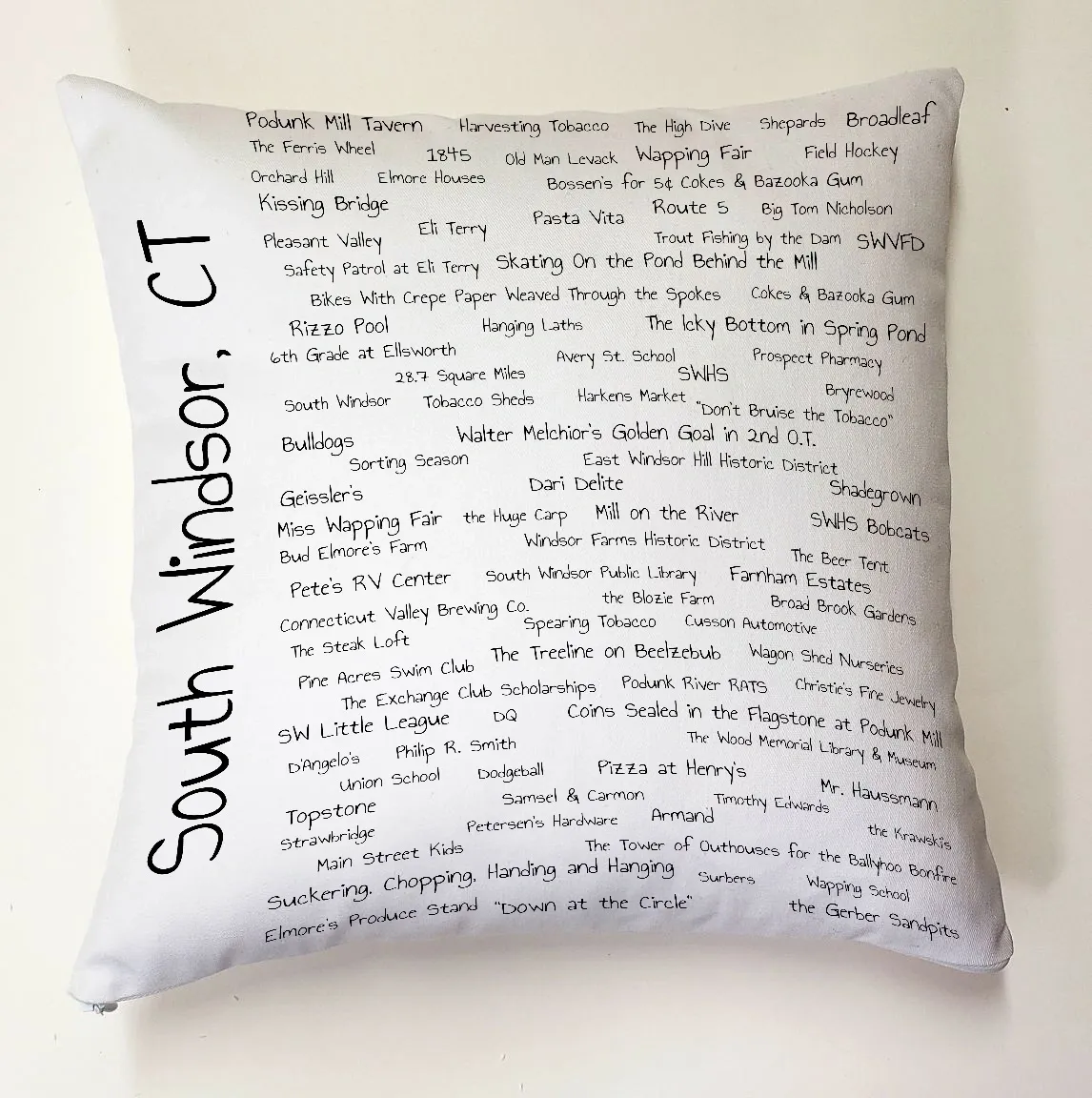 A pillow with the names of many different places.