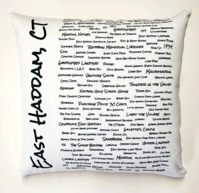 A white pillow with black writing on it.